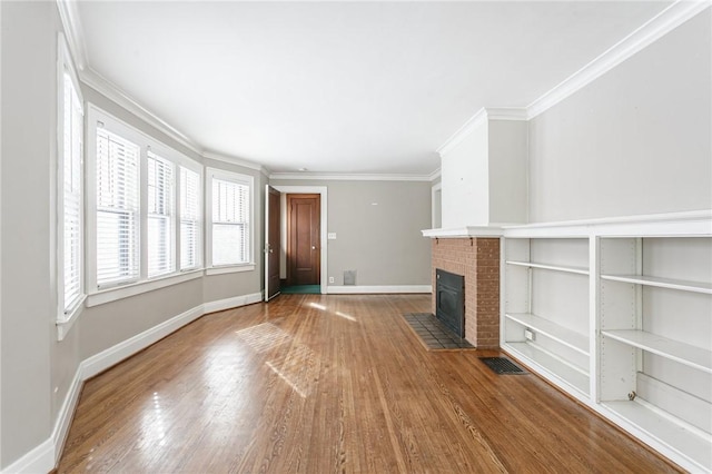 unfurnished living room featuring a brick fireplace, wood-type flooring, and ornamental molding