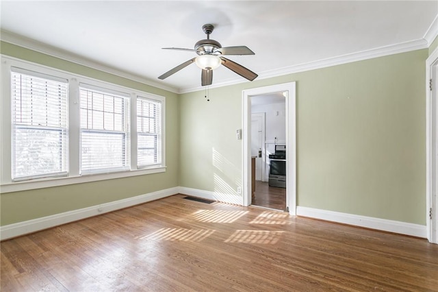 spare room with crown molding, ceiling fan, and hardwood / wood-style flooring