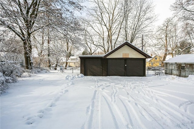 snow covered structure featuring a garage