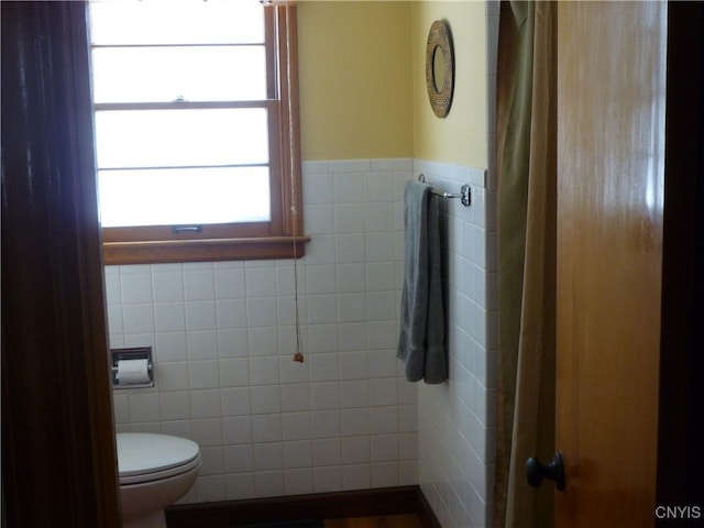 bathroom featuring tile walls and toilet