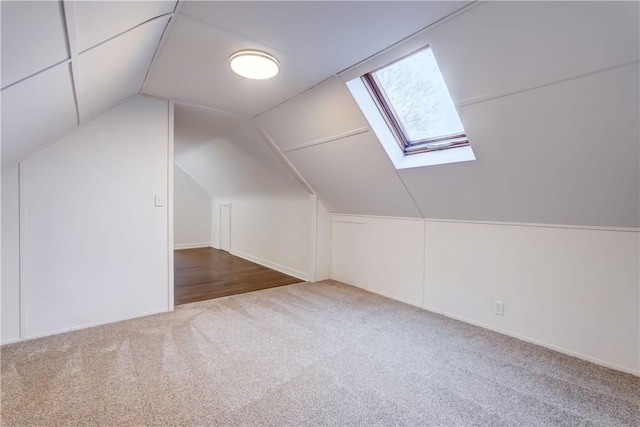 additional living space with carpet floors and vaulted ceiling with skylight