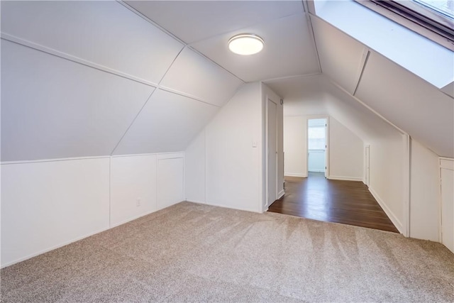 additional living space with dark colored carpet and lofted ceiling