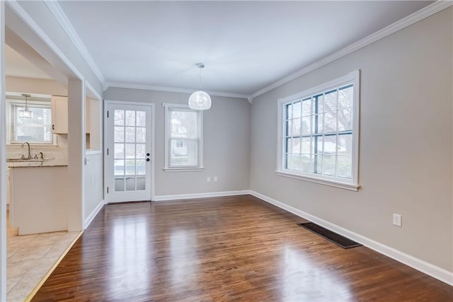 interior space featuring hardwood / wood-style floors, crown molding, and sink