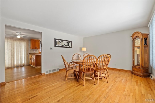 dining space featuring ceiling fan and light wood-type flooring