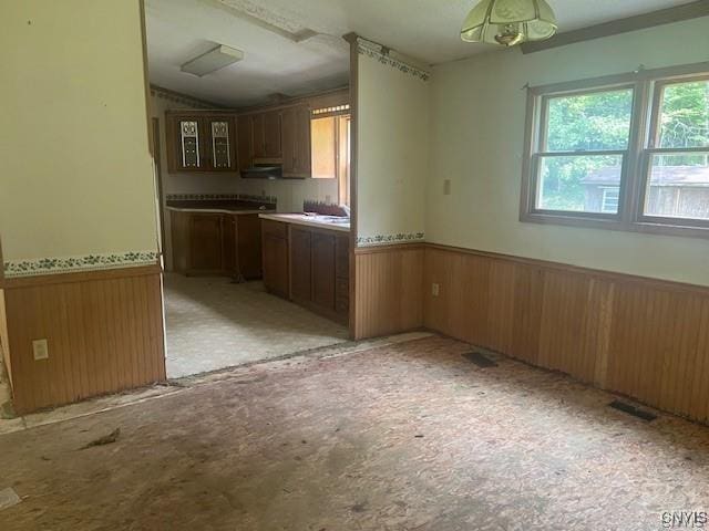 kitchen with lofted ceiling and wood walls