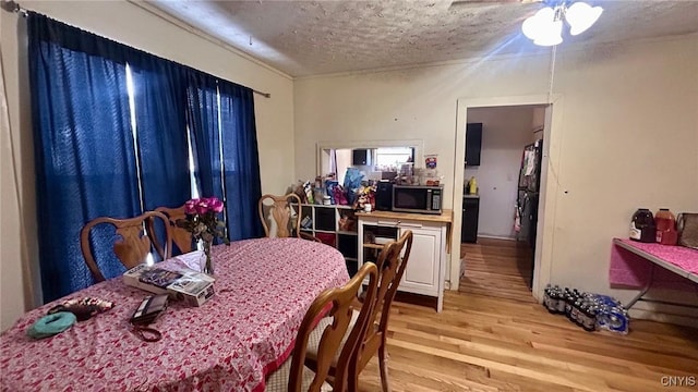 dining room with a textured ceiling and light wood-type flooring