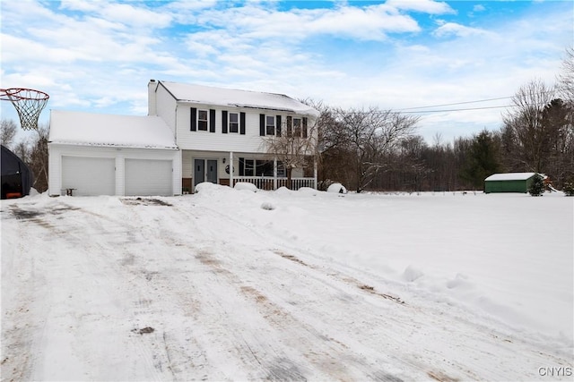 view of property with a garage and a porch