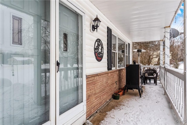 view of snow covered back of property