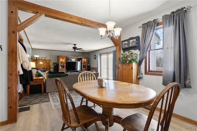 dining space featuring ceiling fan with notable chandelier and light hardwood / wood-style floors