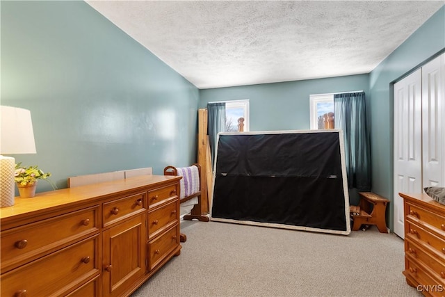 carpeted bedroom featuring a closet and a textured ceiling