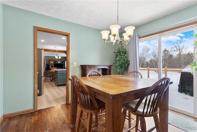 dining area with hardwood / wood-style floors and a chandelier