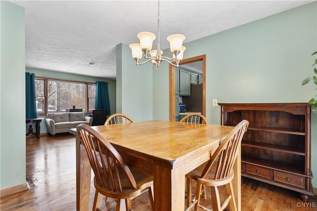 dining room with an inviting chandelier, dark hardwood / wood-style floors, and a textured ceiling