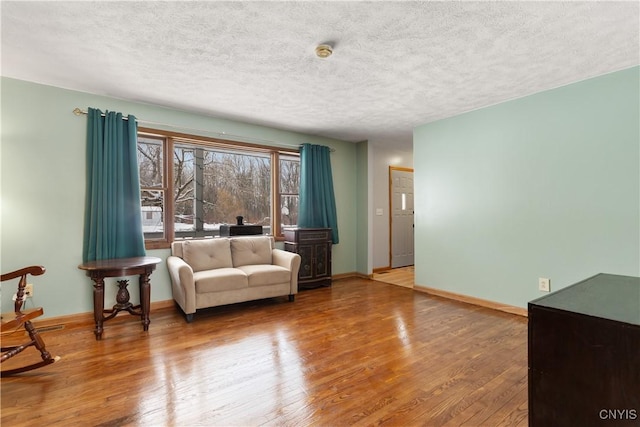 sitting room with hardwood / wood-style floors and a textured ceiling