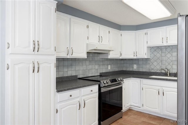 kitchen featuring appliances with stainless steel finishes, tasteful backsplash, sink, white cabinets, and light tile patterned floors