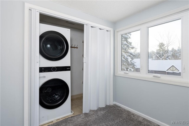 clothes washing area with stacked washer / drying machine and carpet flooring