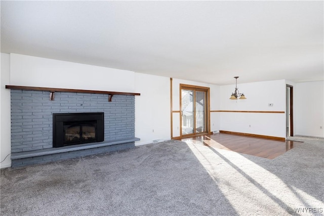 unfurnished living room with carpet flooring and a brick fireplace