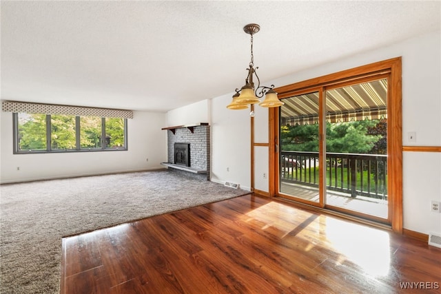 5293E Chestnut Ridge Rd Unit E, Orchard Park, NY 14127 - unfurnished living room featuring wood finished floors, a fireplace, and baseboards