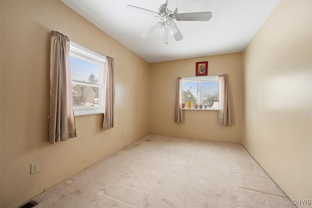 unfurnished room with light carpet, ceiling fan, and a healthy amount of sunlight