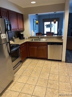 kitchen with pendant lighting, appliances with stainless steel finishes, sink, and light tile patterned floors