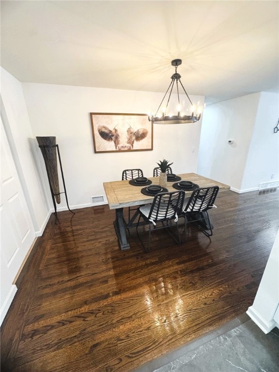 dining room featuring dark wood-type flooring and an inviting chandelier