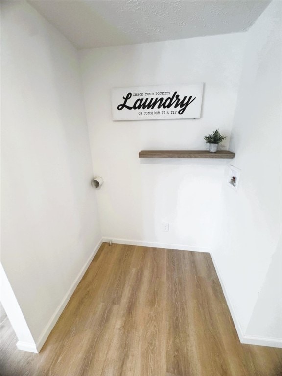 interior space with washer hookup, hardwood / wood-style floors, and a textured ceiling