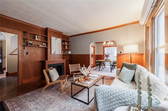 living room featuring hardwood / wood-style flooring, ornamental molding, a tile fireplace, and a wealth of natural light