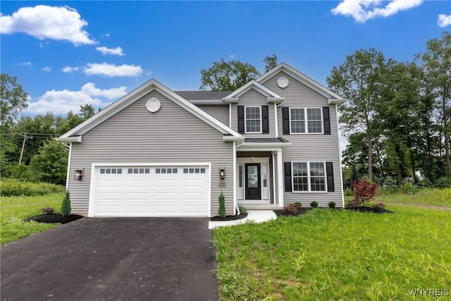 view of property featuring a garage and a front lawn