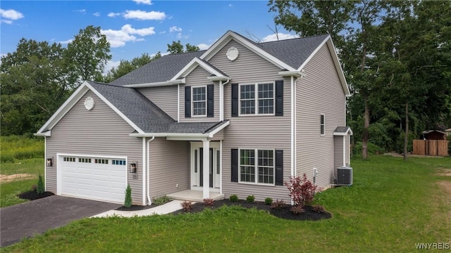 view of front of home with a garage, central air condition unit, and a front lawn