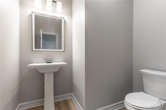 bathroom featuring hardwood / wood-style floors and toilet