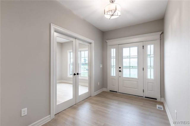 entryway with french doors and light hardwood / wood-style floors