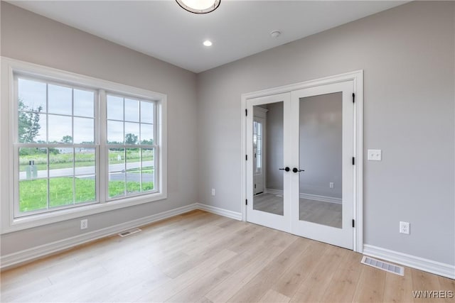 empty room with french doors and light hardwood / wood-style floors