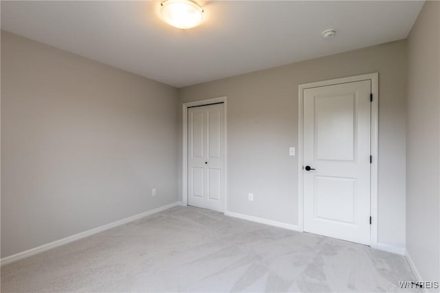 unfurnished bedroom featuring light carpet and a closet