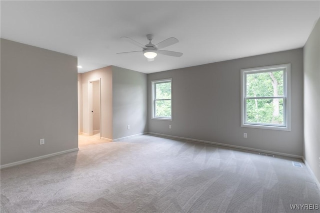 spare room with ceiling fan and light colored carpet