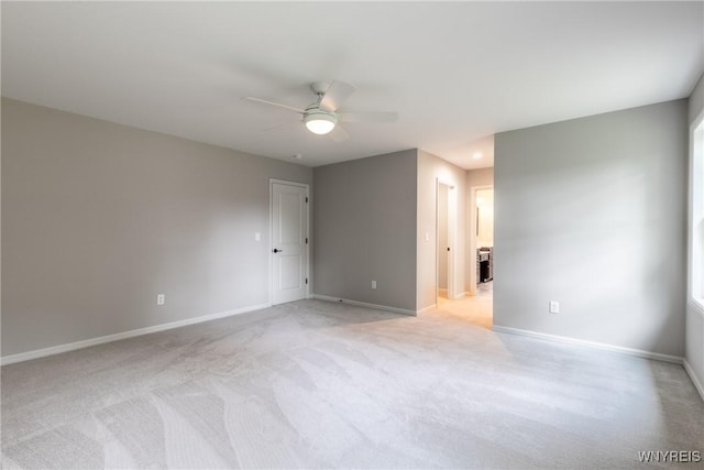 spare room with light colored carpet and ceiling fan