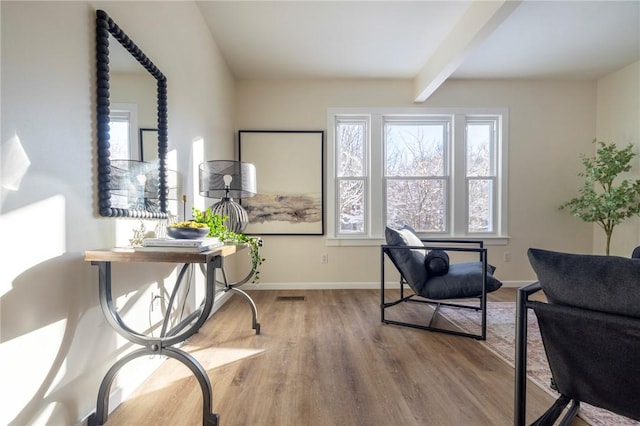 living area with hardwood / wood-style floors and beam ceiling