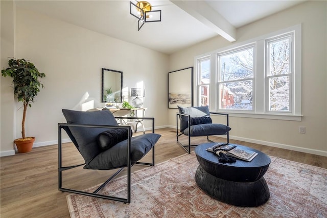 sitting room with beamed ceiling and light hardwood / wood-style flooring