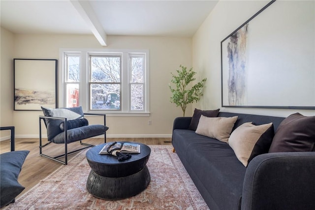 living room featuring beamed ceiling and light hardwood / wood-style floors