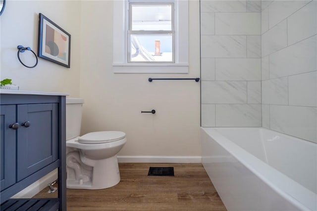 full bathroom with vanity, wood-type flooring, tiled shower / bath, and toilet