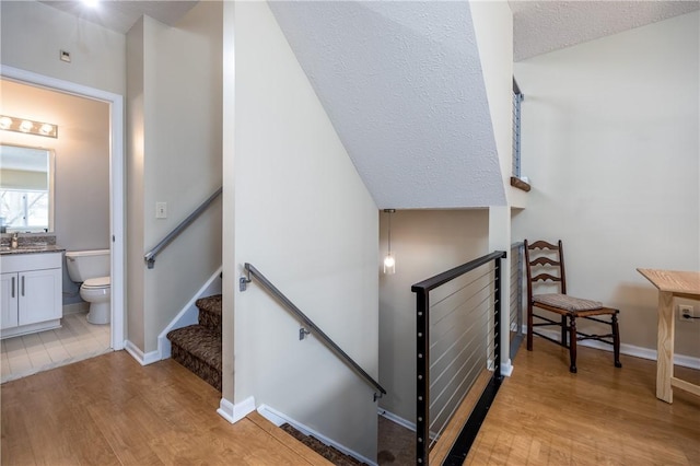 staircase with wood-type flooring and sink