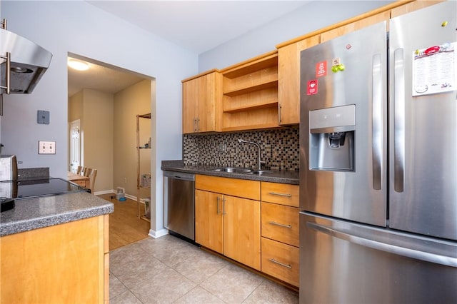 kitchen with sink, light tile patterned floors, appliances with stainless steel finishes, range hood, and tasteful backsplash