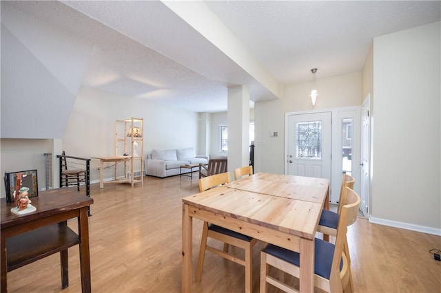 dining space featuring a textured ceiling and light hardwood / wood-style flooring