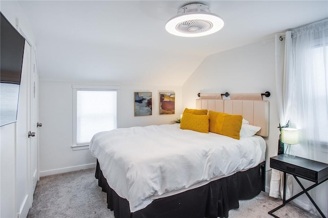 carpeted bedroom with lofted ceiling