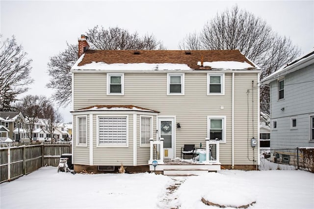 view of snow covered back of property