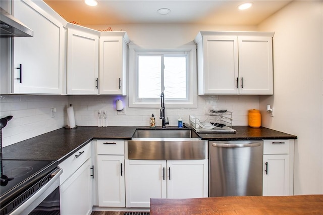 kitchen featuring wall chimney exhaust hood, sink, white cabinetry, stainless steel appliances, and decorative backsplash