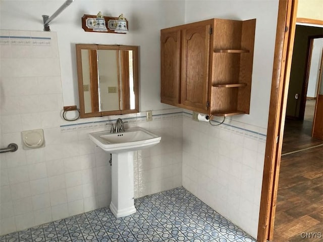 bathroom featuring tile walls and sink