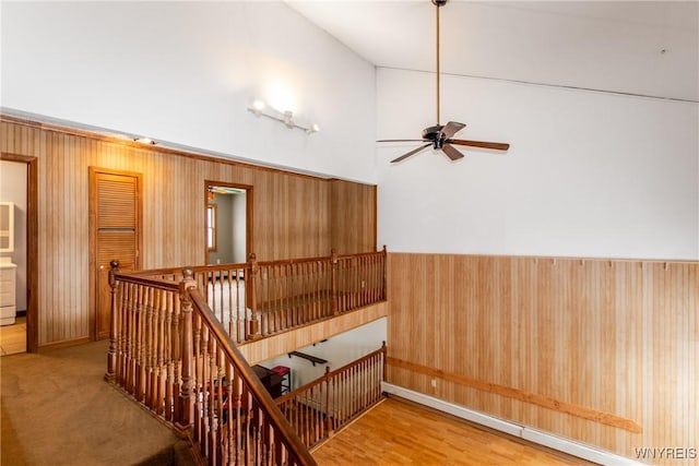 interior space with ceiling fan, a towering ceiling, and wood-type flooring