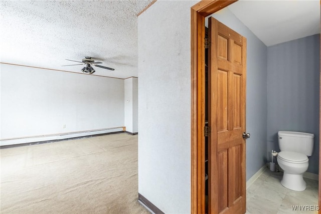 bathroom with a baseboard heating unit, a textured ceiling, toilet, and ceiling fan