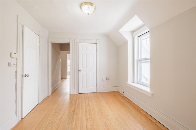 additional living space featuring light hardwood / wood-style flooring and vaulted ceiling