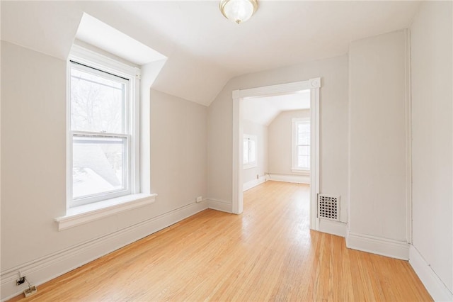 bonus room featuring vaulted ceiling and light wood-type flooring