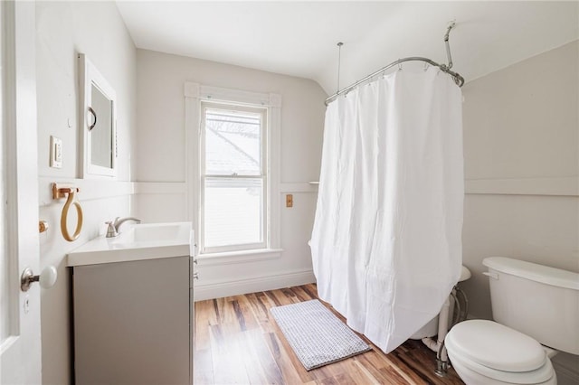 bathroom with hardwood / wood-style flooring, vanity, curtained shower, and toilet